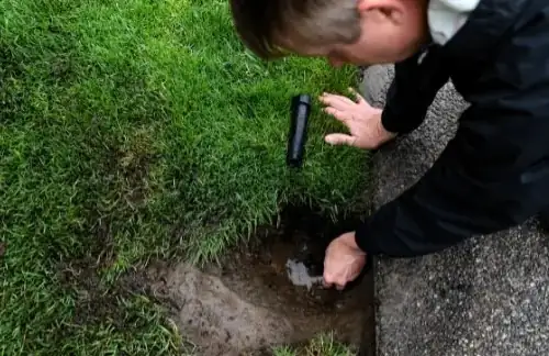 Hands setting a pop-up sprinkler head